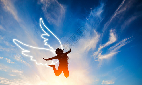 手中的天使跳跃的美女剪影与翅膀设计图片