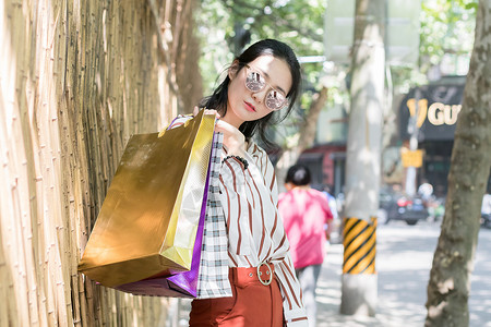 拿购物袋女孩时尚女生逛街购物街拍背景