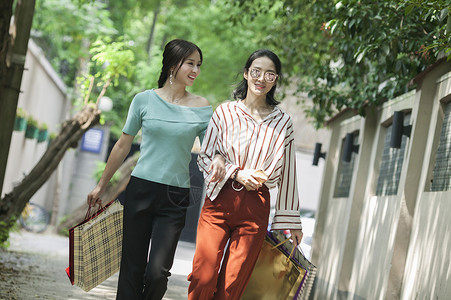 女性闺蜜在小路上逛街购物背景图片