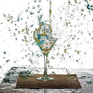 蓝色与黄色的饮料在杯中溅出水珠高清图片