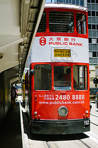 穿梭巴士穿梭在香港繁荣区域中环的电车背景