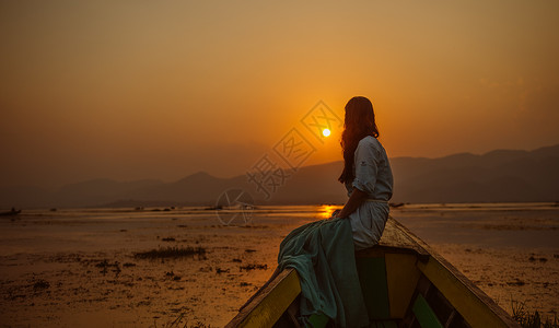 在湖面游船湖上欣赏日落的女孩背景