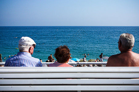 海洋健康阳光下面对蓝色海洋的老人背景