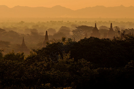 蒲甘古城的佛塔群映衬在朝阳薄雾的群山中背景图片