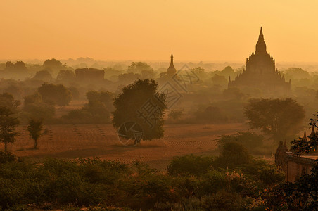 缅甸蒲甘古城平原上的佛塔映衬在早霞薄雾中背景图片