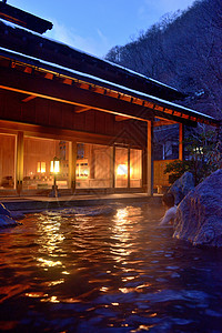 建筑木冬季傍晚浸泡在日本乡村温泉池中背景