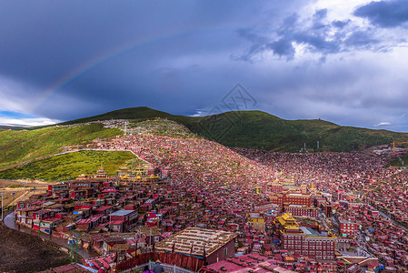天空彩虹素材彩虹下的色达喇荣寺五明佛学院背景