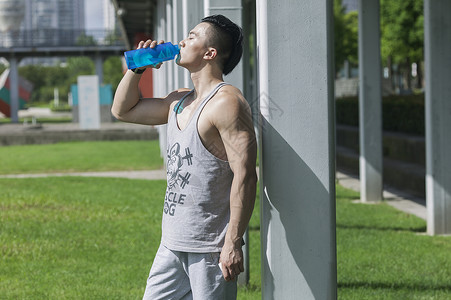 运动健身饮料男孩在户外运动后喝运动饮料背景