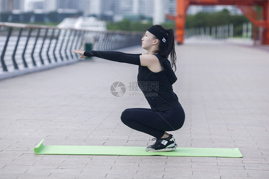 女性在户外瑜伽垫上锻炼形体图片