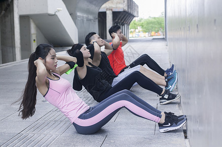 年轻男女在户外运动场所热身运动高清图片