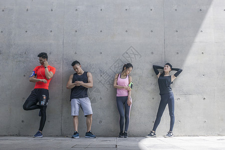 年轻男女在户外运动场所热身运动背景图片