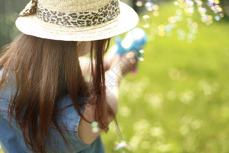 漂亮的女孩子草地里坐着的戴帽子的女孩子背景