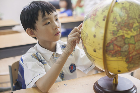 手绘潜能开发课程素材教室里男同学正在研究地球仪背景