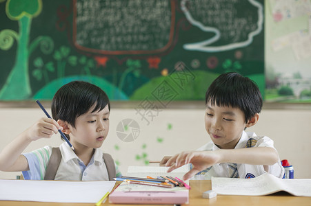 知识答题素材小学生男同学在教室上课做作业背景