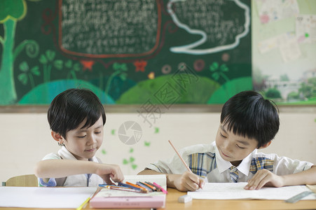 知识答题素材小学生男同学在教室上课做作业背景