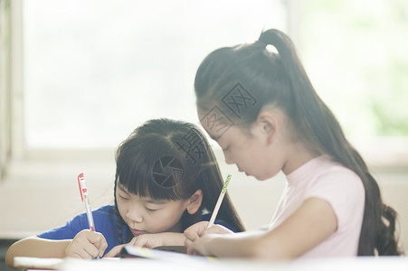 知识答题素材小学生在教室里做功课背景