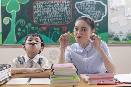 寓教于乐教室里女老师陪男同学学习玩耍背景