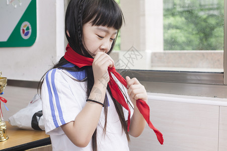 红领巾少年女同学在教室里打红领巾背景
