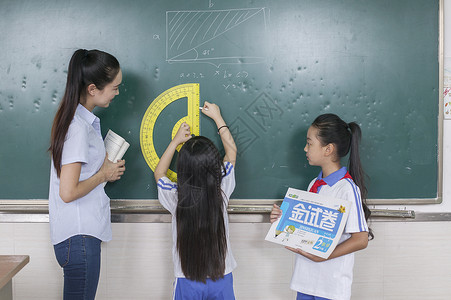 粉笔和试卷女老师在教室给同学上数学课背景