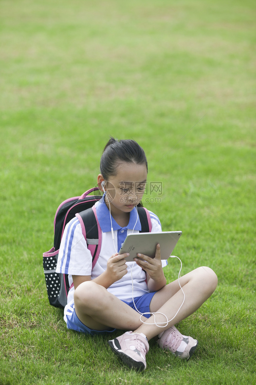 女同学在学校草坪上用ipad学习图片