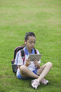 女同学在学校草坪上用ipad学习图片