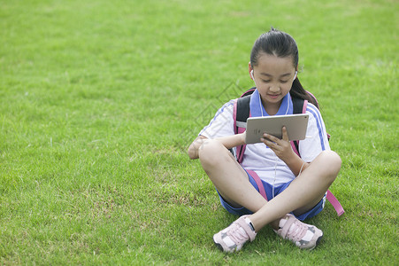 女同学在学校草坪上用ipad学习图片