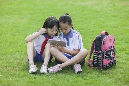 女同学在学校里草坪上用ipad 学习图片