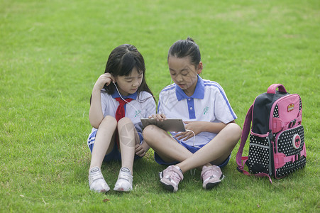 女同学在学校里草坪上用ipad 学习图片