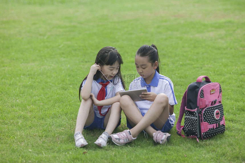 女同学在学校里草坪上用ipad 学习图片