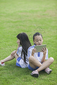 女同学在学校里草坪上用ipad 学习图片