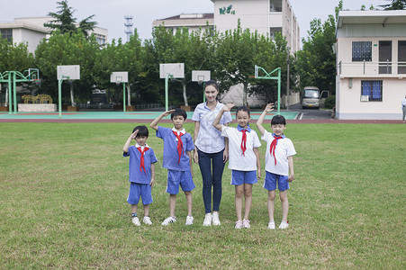 合乎道德女老师和男女同学在操场上升国旗敬礼背景