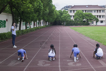 男女同学在操场跑道上比赛跑步图片