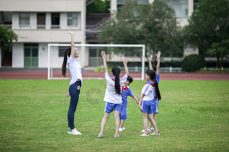 校草校园里女老师和同学们在草坪上一起玩耍背景