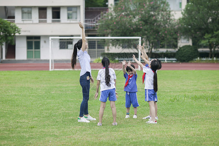 校草校园里女老师和同学们在草坪上一起玩耍背景
