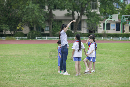 校花校草校园里女老师和同学们在草坪上一起玩耍背景