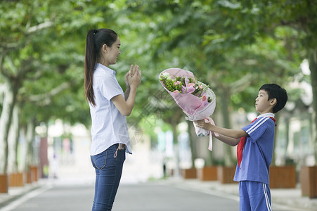 教师节男同学在校园里给老师献花图片