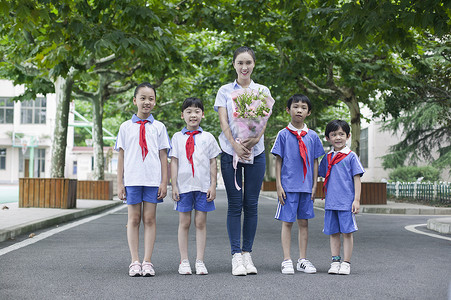 礼貌教育素材教师节男女同学们和女老师在校园里给老师献花背景