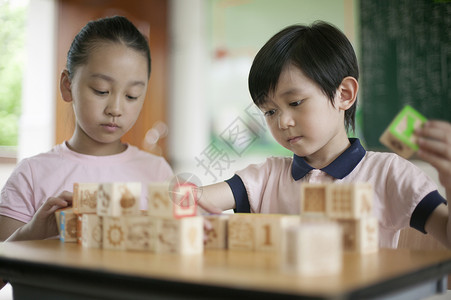男女同学在教室里一起玩积木高清图片