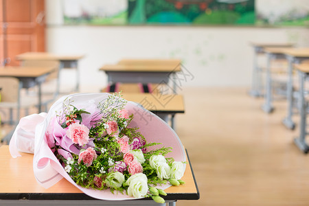 老师送花教师节教室书桌上的鲜花背景