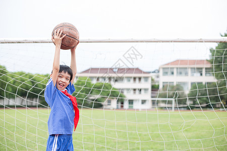 小学体育在球场上踢球玩耍的小学生背景