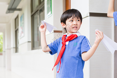 下课在走廊上玩飞机的小学生高清图片