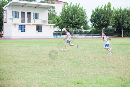 小学运动会操场上跑步运动的小学生背景