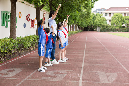 小学老师带着同学们在操场上玩耍欢呼背景图片