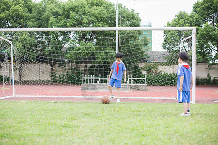 在球场上踢球玩耍的小学生背景图片