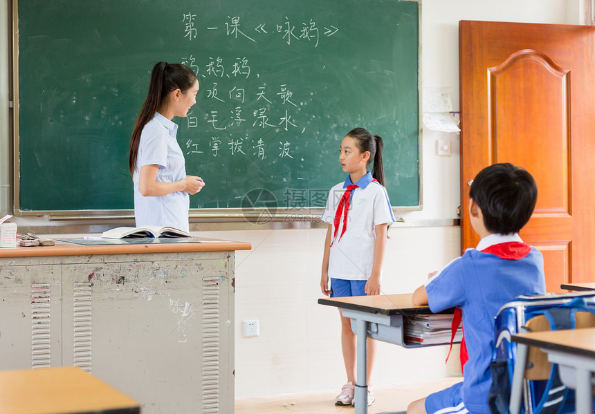 站在教室黑板前思考问题的小学生图片