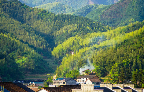 层层叠叠的绿山和炊烟袅袅的小镇高清图片