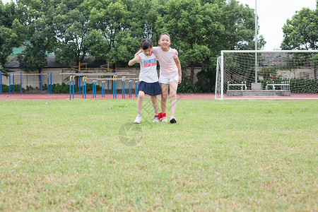 两人三足游戏小学生在操场草坪运动玩游戏背景