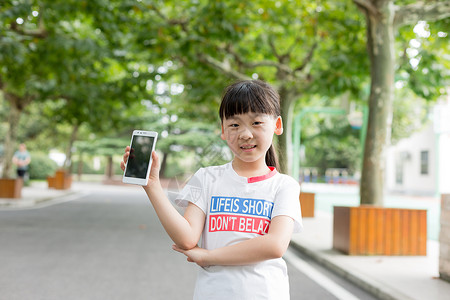 站在校园里玩手机的小学生女生图片