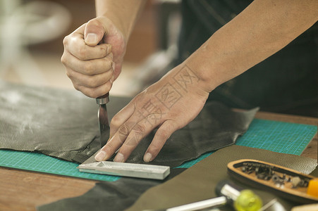 闪艺人物素材皮匠师傅专注的在裁切皮革背景