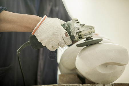 专注的石匠师傅在打磨石雕背景图片